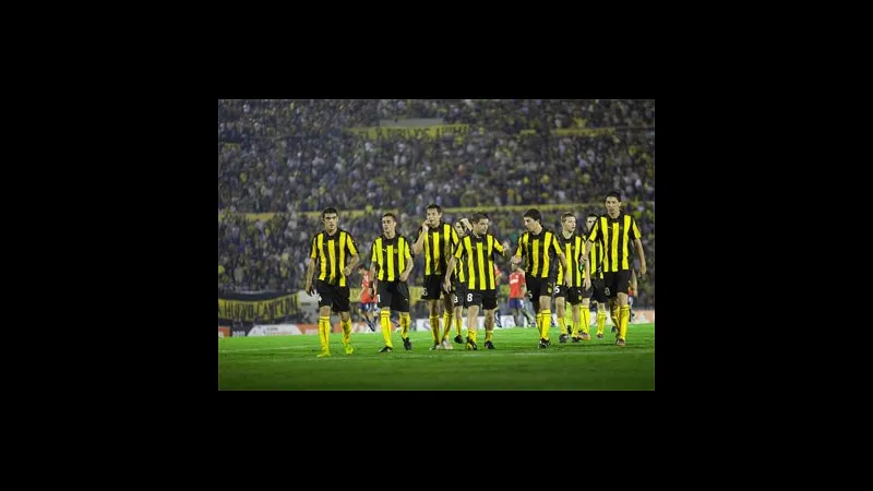 Cầu thủ Racing Montevideo và Penarol đang tranh chấp bóng trên sân